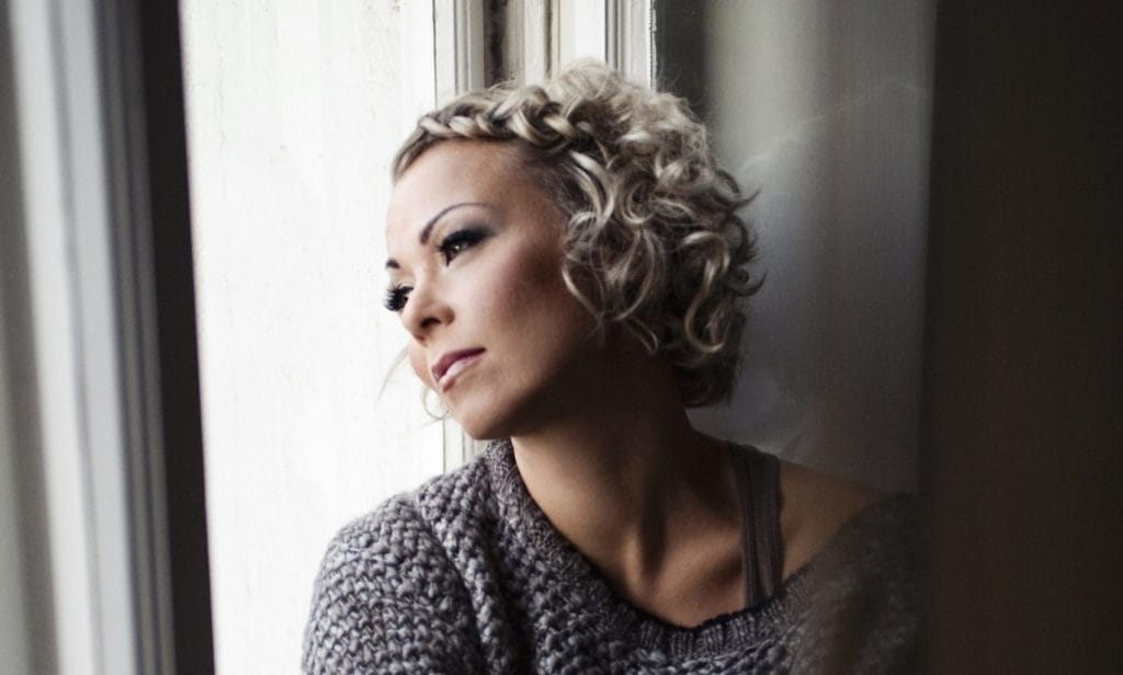 Tangokuningatar Johanna Pakonen vakavassa kuvassa, katsoo ikkunasta ulos