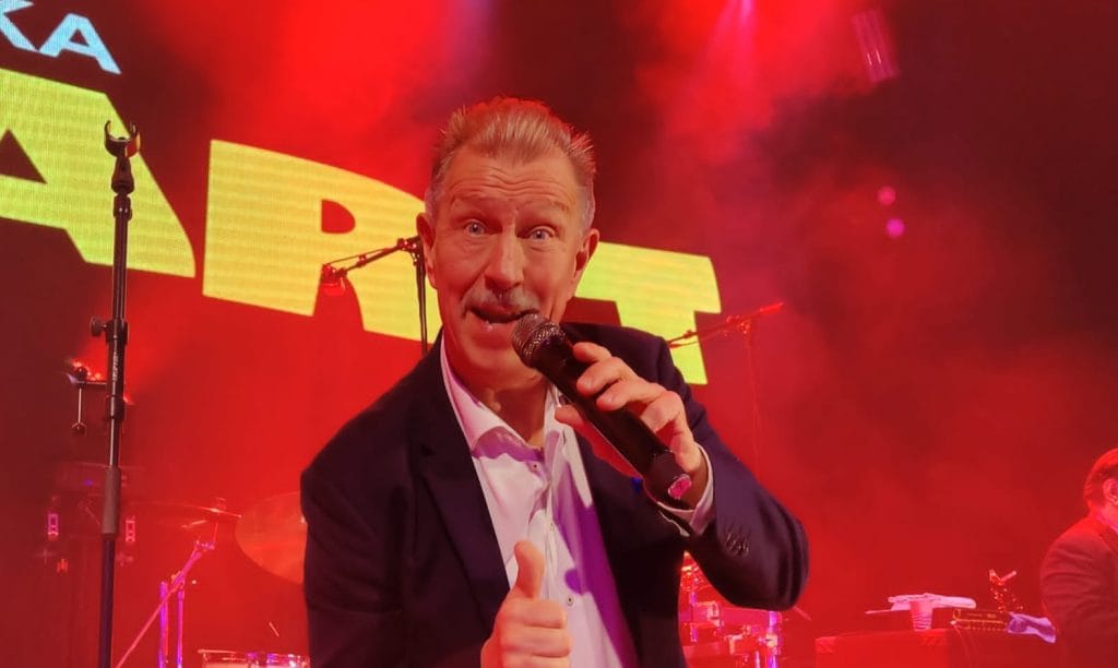 Lasse Hoikka esiintymislavalla mikrofonin kanssa.