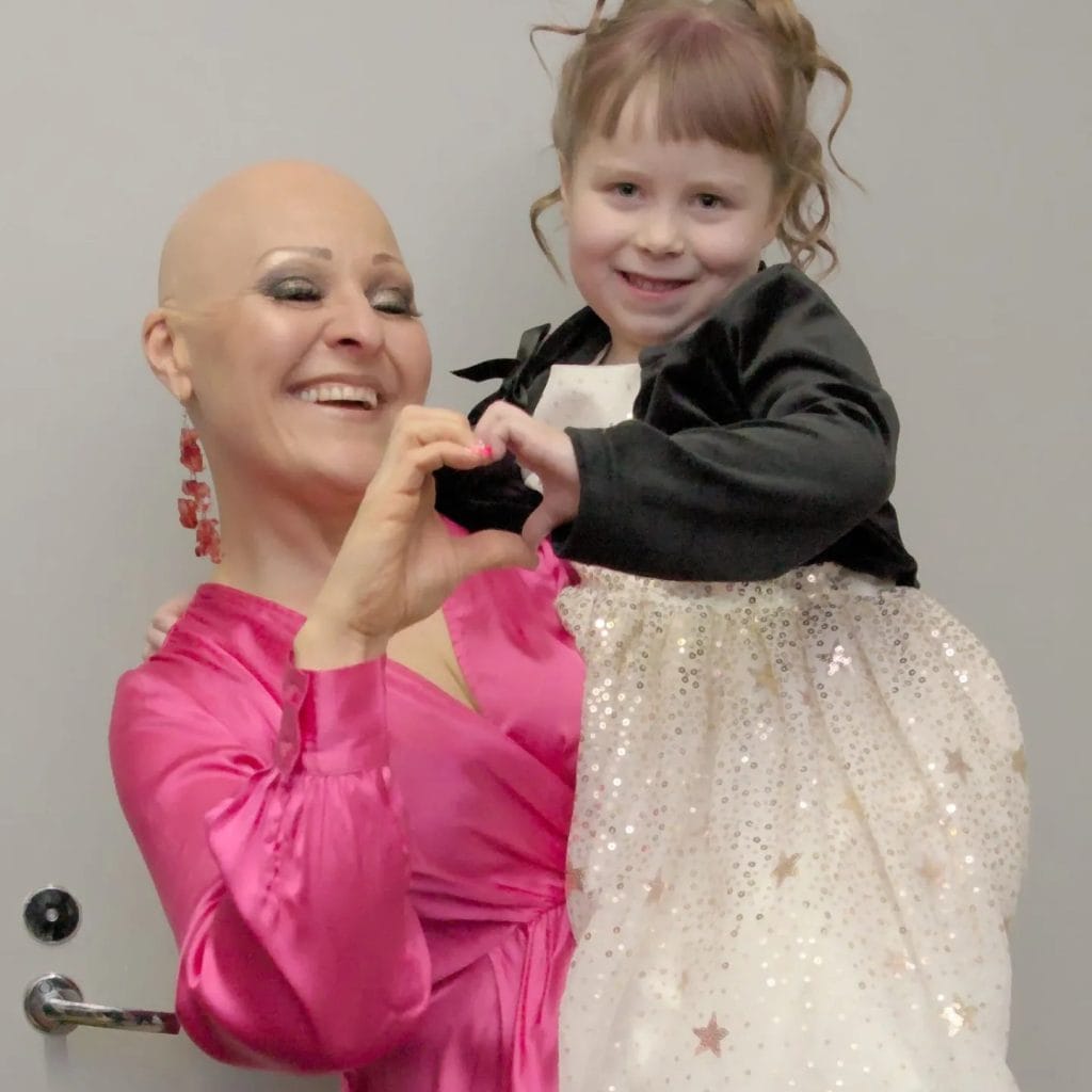 Katja karisukki ja sylvi takatalo 8 poseeraavat hymyillen ja tekevät sydänmerkin yhteisen joululaulunsa julkaisun yhteydessä