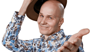 tangokuningas marko manuksela pitää kädellään hattua ja osoittaa toisella kädellään kameraa 2025